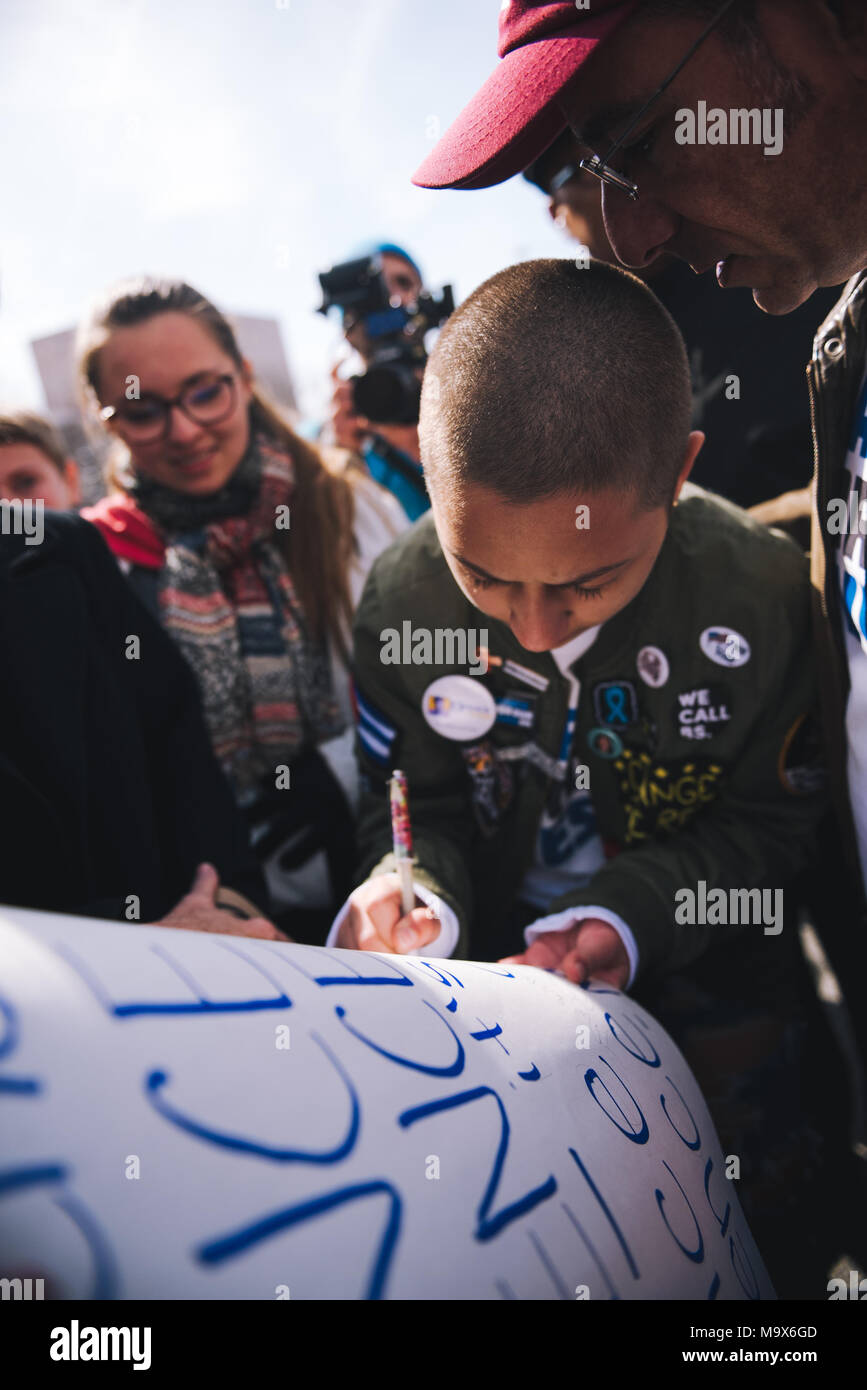 Washington Dc, USA. 24th Mar, 2018. Emma Gonzalez signs a poster with Martin Luther King Jr quote on it, that also was signed by Martin Luther King III, at March for our lives.Tens of thousands of Americans took to the street on Washington DC during the ''March for our Lives'' demonstration against gun violence in schools in the United States. Credit: Emilee Mcgovern/SOPA Images/ZUMA Wire/Alamy Live News Stock Photo