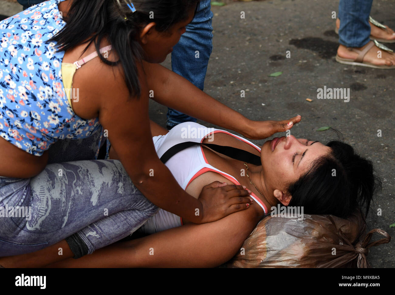 Carabobo, Venezuela. 28th Mar, 2018. A woman faints as relatives wait for information after an alleged fire at a Venezuelan police station, in Valencia, Carabobo state, Venezuela, on March 28, 2018. A prison riot and fire has broken out at a Venezuelan police station in the central city of Valencia and at least 68 people were killed, Venezuelan officials said Wednesday. Credit: Roman Camacho/SOPA/ZUMAPRESS/Xinhua/Alamy Live News Stock Photo