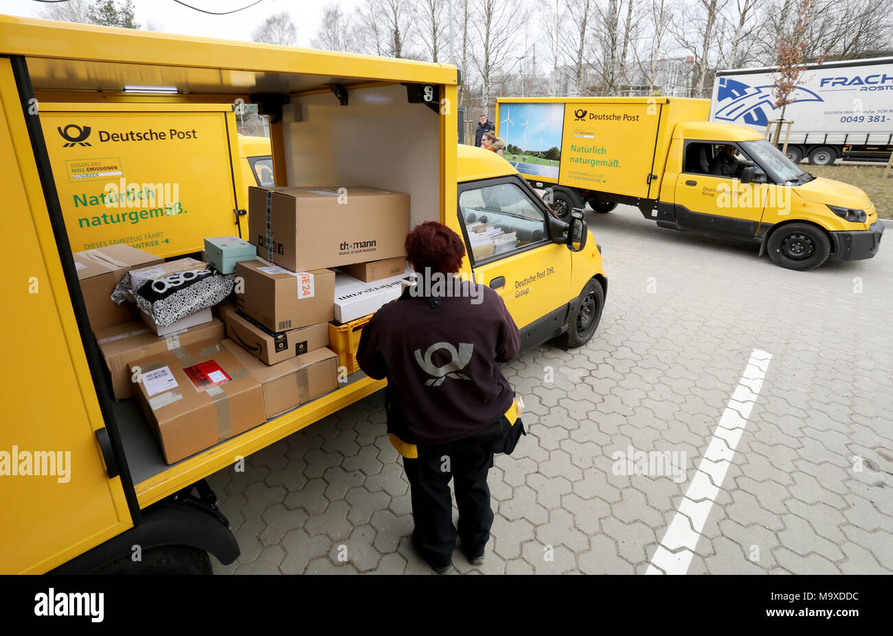 Rostock, Germany. 28th Mar, 2018. 28.03.2018, Mecklenburg-Western  Pomerania, Rostock: At the Deutsche Post delivery base, small electric vans  will be parked at a press event and loaded with parcels. A street scooter