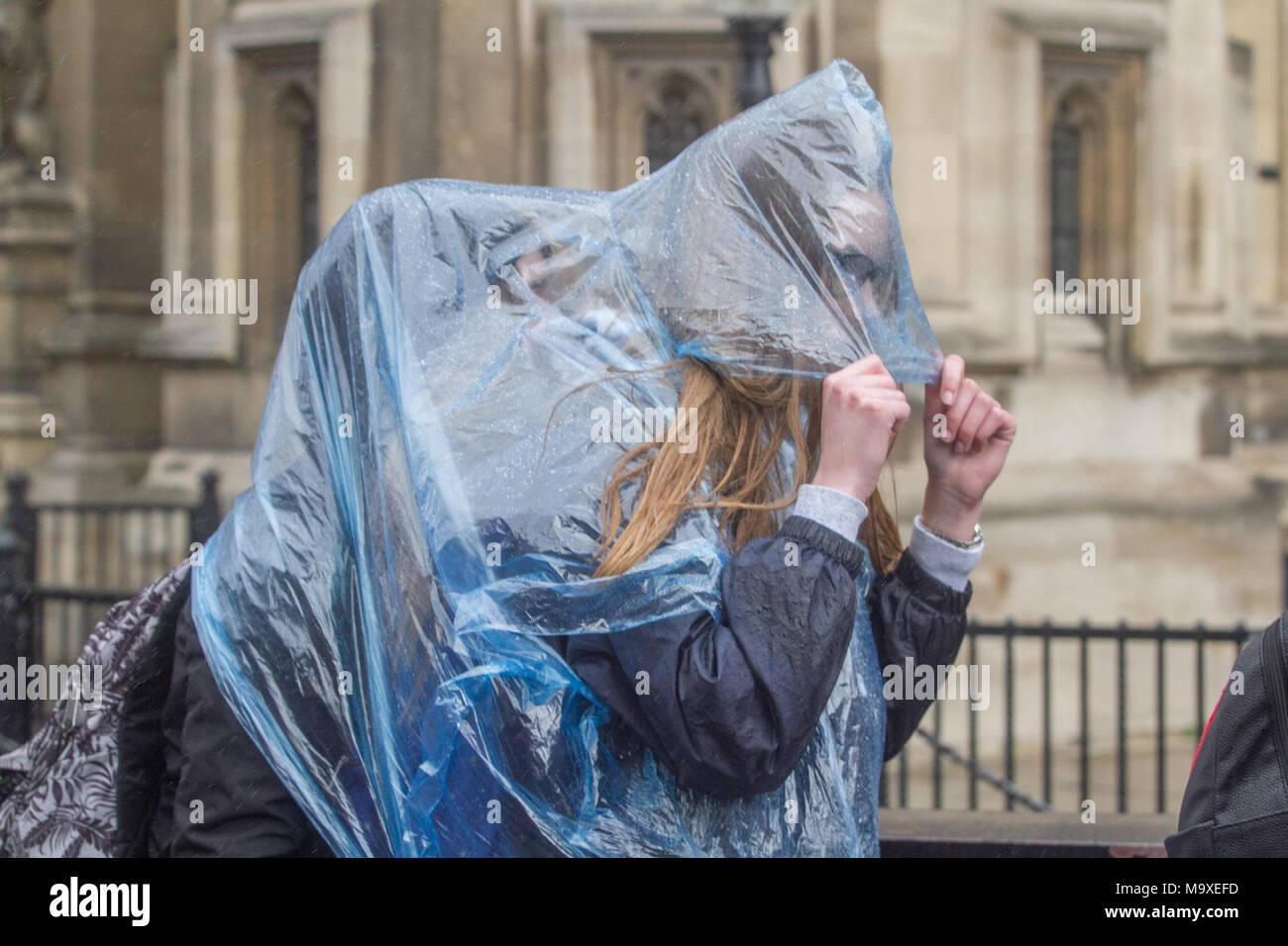 London, UK. 29th March 2018. Pedestrians share a rain poncho in Westminster  as London is hit by heavy rain showers Credit: amer ghazzal/Alamy Live News  Stock Photo - Alamy