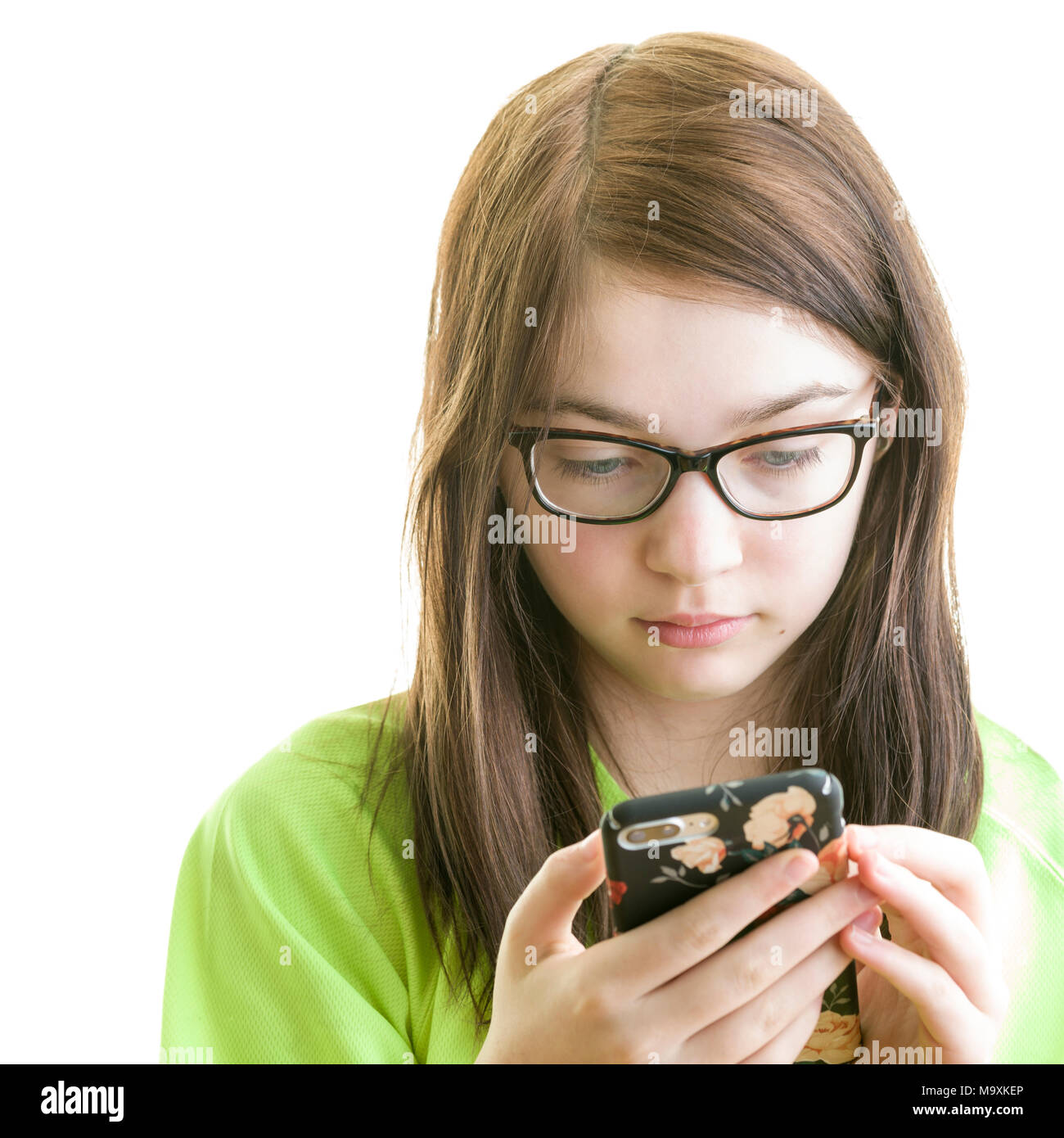 Close up portrait of a brunette young Caucasian teenage girl using smartphone isolated on a white background Stock Photo