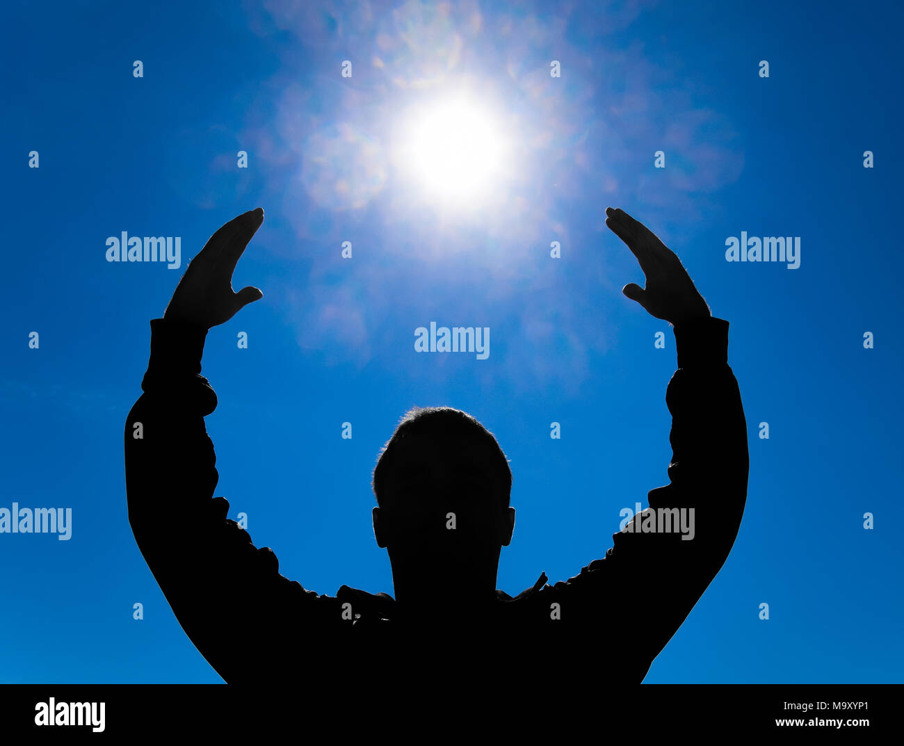 Silhouette of a man against the background of the sun and blue sky ...