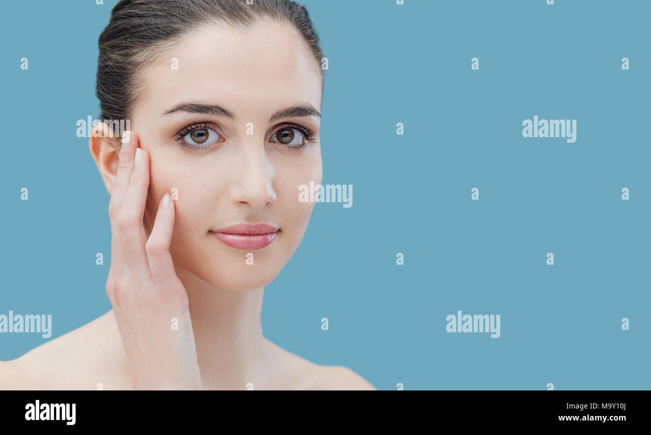 Beautiful young smiling girl touching her face, beauty and skincare ...