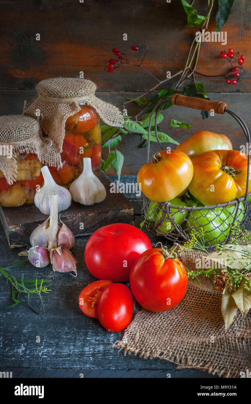 Homemade canned tomatoes in glass jars in a rustic style. The concept of cultivation, harvesting