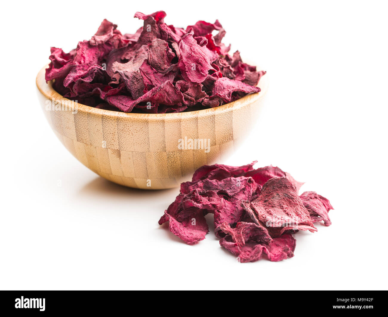 Dried beetroot chips in bowl isolated on white background. Stock Photo
