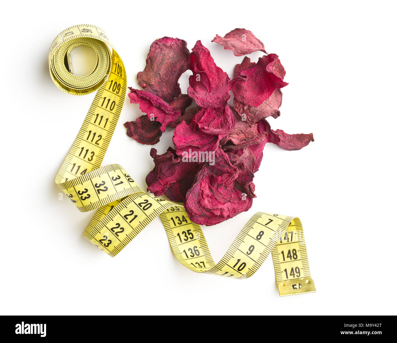 Dried beetroot chips and measuring tape isolated on white background. Stock Photo