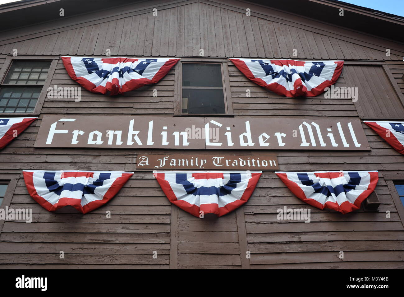Sign on side of wooden building "A Family Tradition" with patriotic