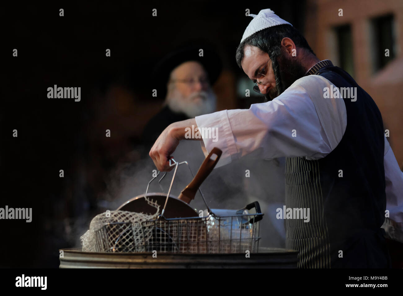 A Haredi Jew dip cooking utensils in boiling water in a process called