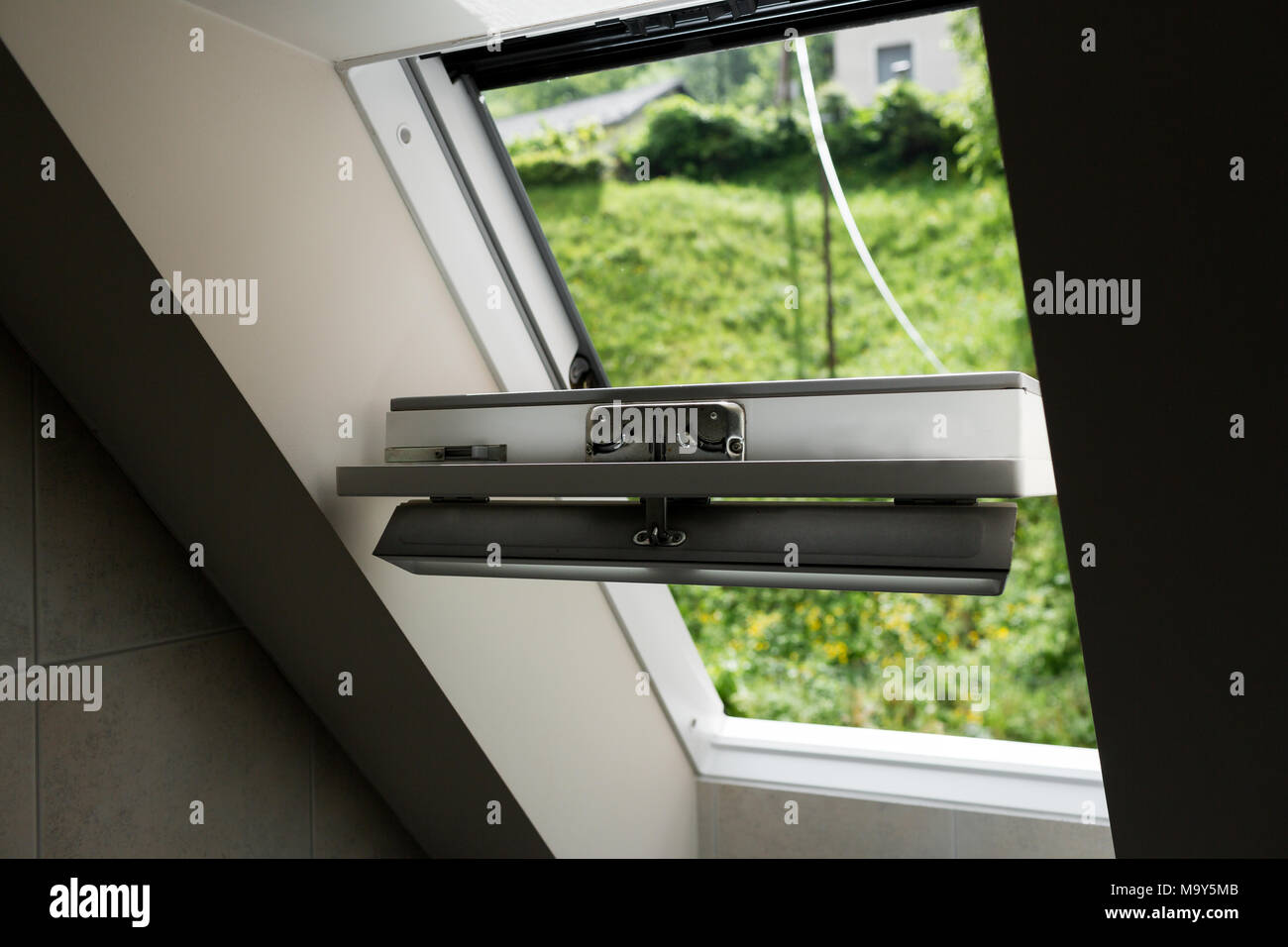 Open roof window, skylight with beautiful view. Plastic mansard on attic with environmentally