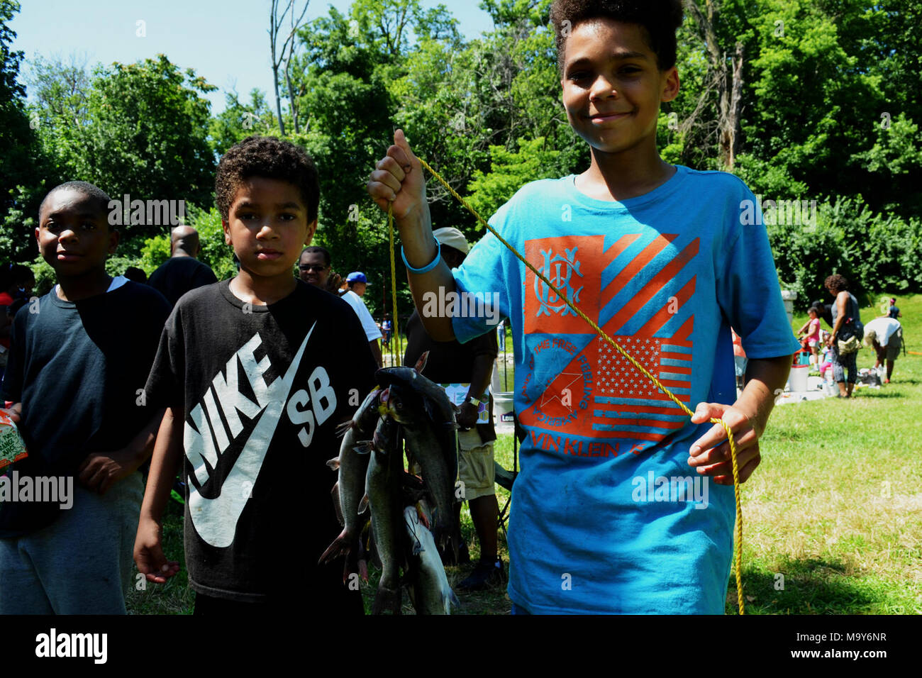 Boys with Fish. Participants in the Urban Kids Fishing Derby in Kansas City,  Missouri show off their catch on the way to the weighing station Stock  Photo - Alamy