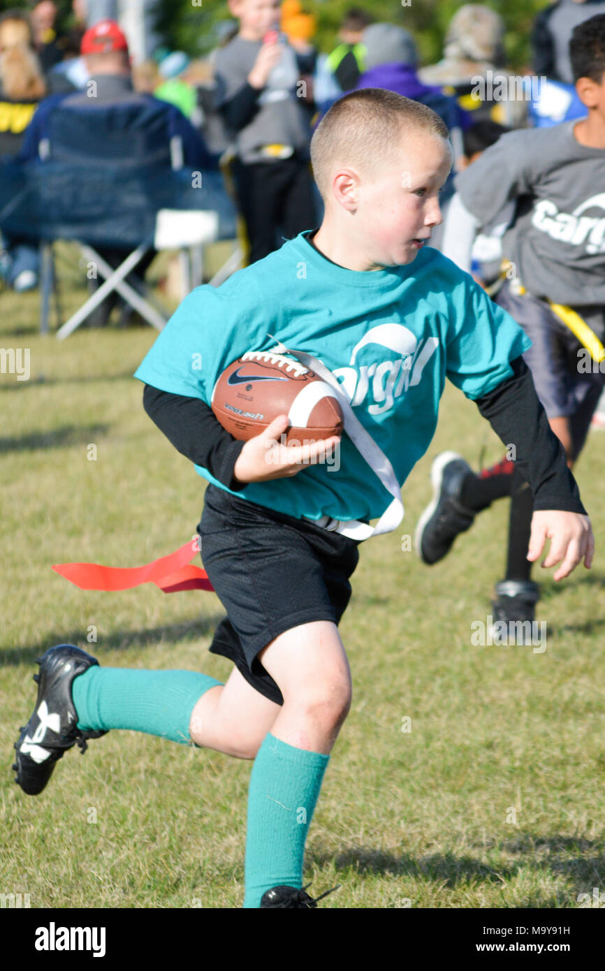 Kid running with the football in a game of flag football, Iowa Stock Photo