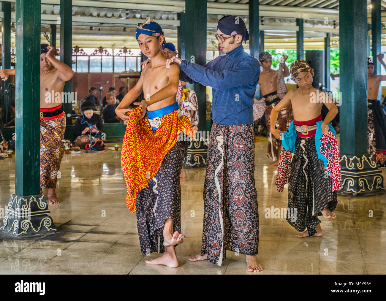 dance instructor correcting the posture of a young dancer during Beksan Putra, traditional male palace dance performance at the Kraton Ngayogyakarta H Stock Photo