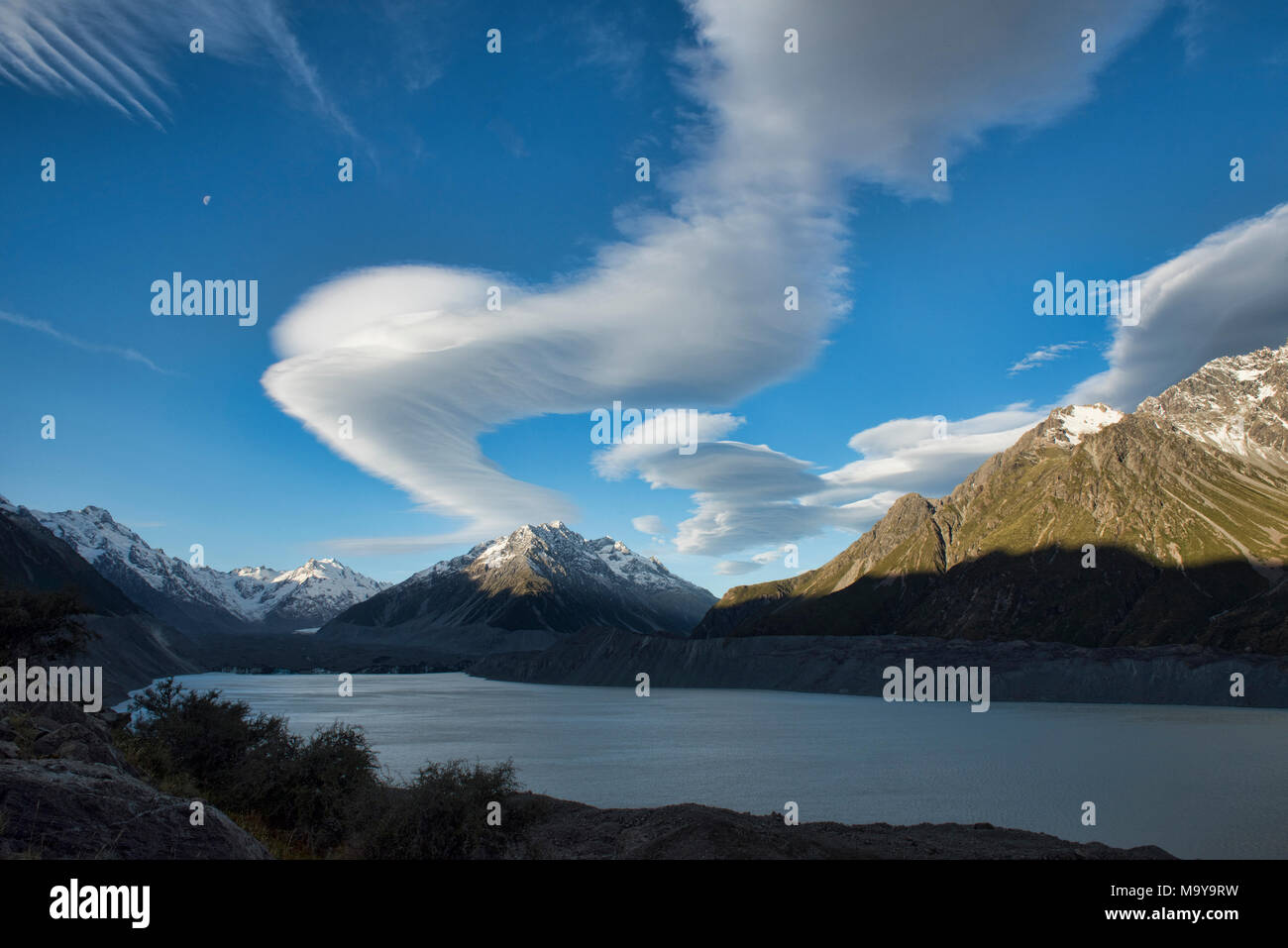 Wild lenticular clouds sail over Lake Tasman and Mount Cook, Southern Alps, New Zealand Stock Photo
