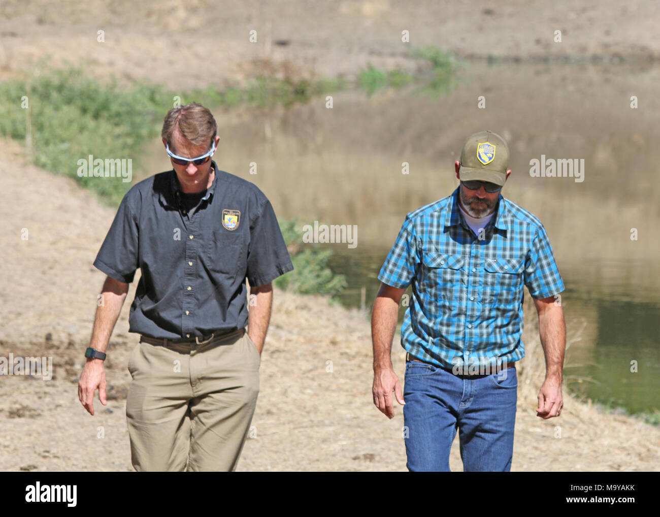 McClure pond. Jeff Phillips (left), conservation banking coordinator with the U.S. Fish and Wildlife Service and Dave Hacker (right), conservation and mitigation banking coordinator with the California Department of Fish and Wildlife at McClure Pond on the Sparling Conservation Bank near Hollister, Calif. Stock Photo