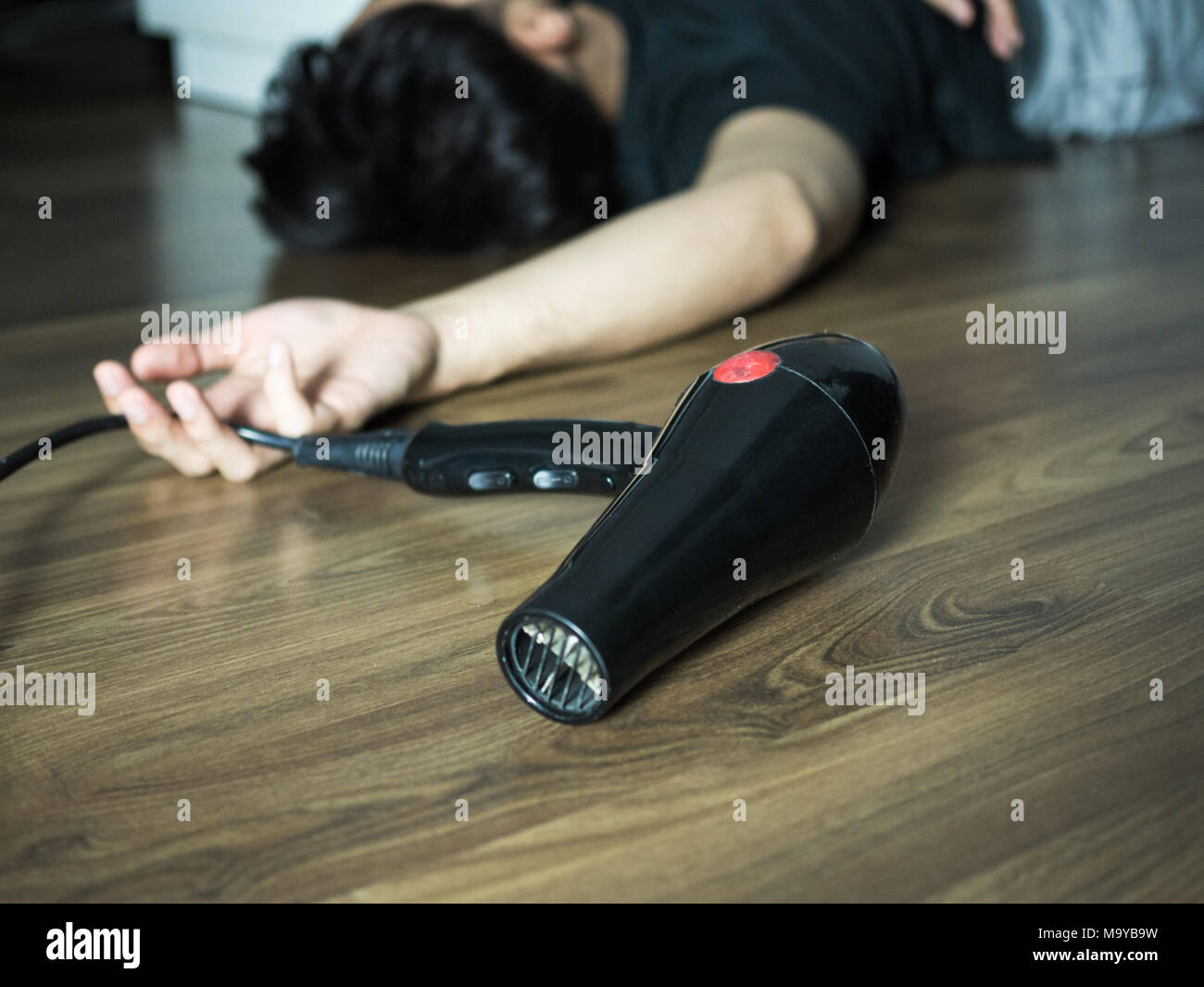 Hair dryer electric shock, accident of man pass out on the floor Stock Photo