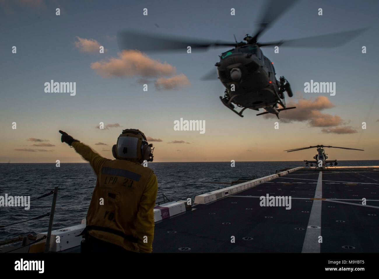 Aviation Support Equipment Technician 2nd Class Yun Zhang, from Los Angeles, Calif., signals to the pilot of a UH-1Y Venom from the Marine Light Attack Helicopter detachment of Marine Medium Tiltrotor Squadron 166 reinforced, the aviation combat element for the 13th Marine Expeditionary Unit (MEU), on the flight deck of the San Antonio-class amphibious transport dock USS Anchorage (LPD 23), during an amphibious squadron and MEU integration (PMINT) exercise. PMINT is a training evolution between Essex Amphibious Ready Group and 13th MEU, which allows Sailors and Marines to train as a cohesive u Stock Photo