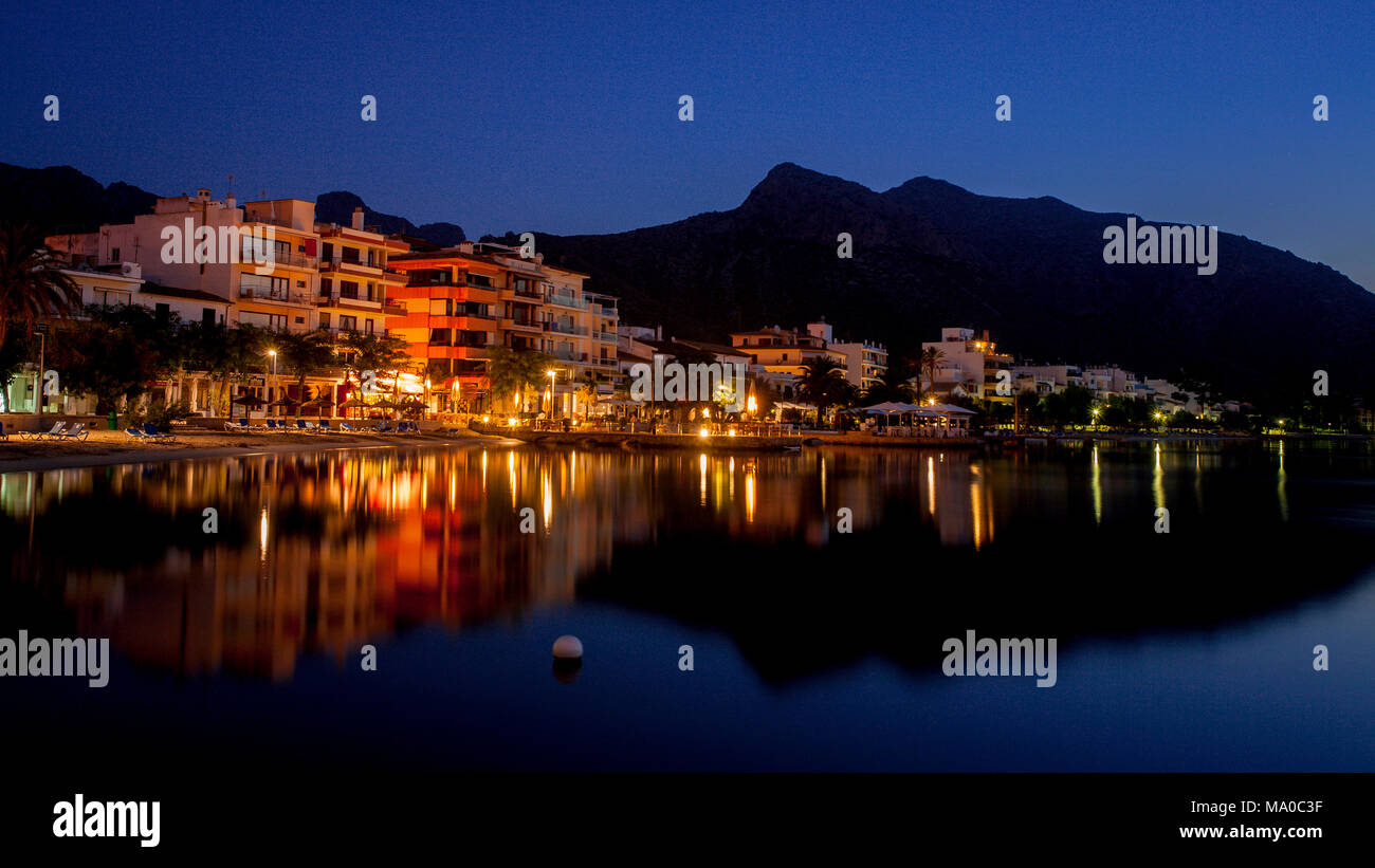 Beach resort at Porto Pollenca, Mallorca, reflecting in the Mediterranean sea at dawn Stock Photo