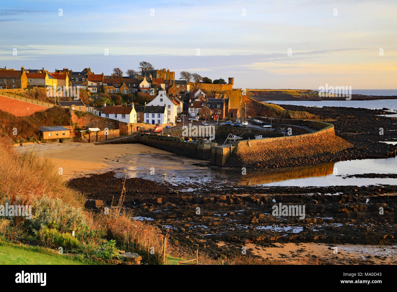 Crail Harbour in the East Neuk of Fife just as the first rays of sunshine hit the land as a new day dawns. Stock Photo