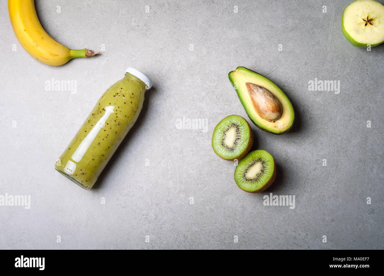 Healthy blended green fruit smoothie in glass bottle with straw. Flat lay, top view Stock Photo