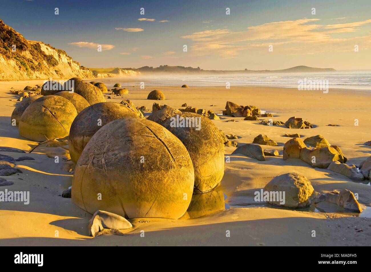 A giant ball shaped boulder almost covered in sand on the beach at Moeraki  South Island New Zealand Stock Photo - Alamy, boulder ball 