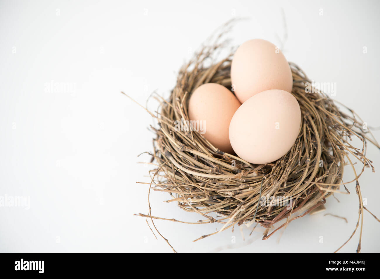 three eggs in the nest, fresh egg for breakfast, easter feast Stock Photo