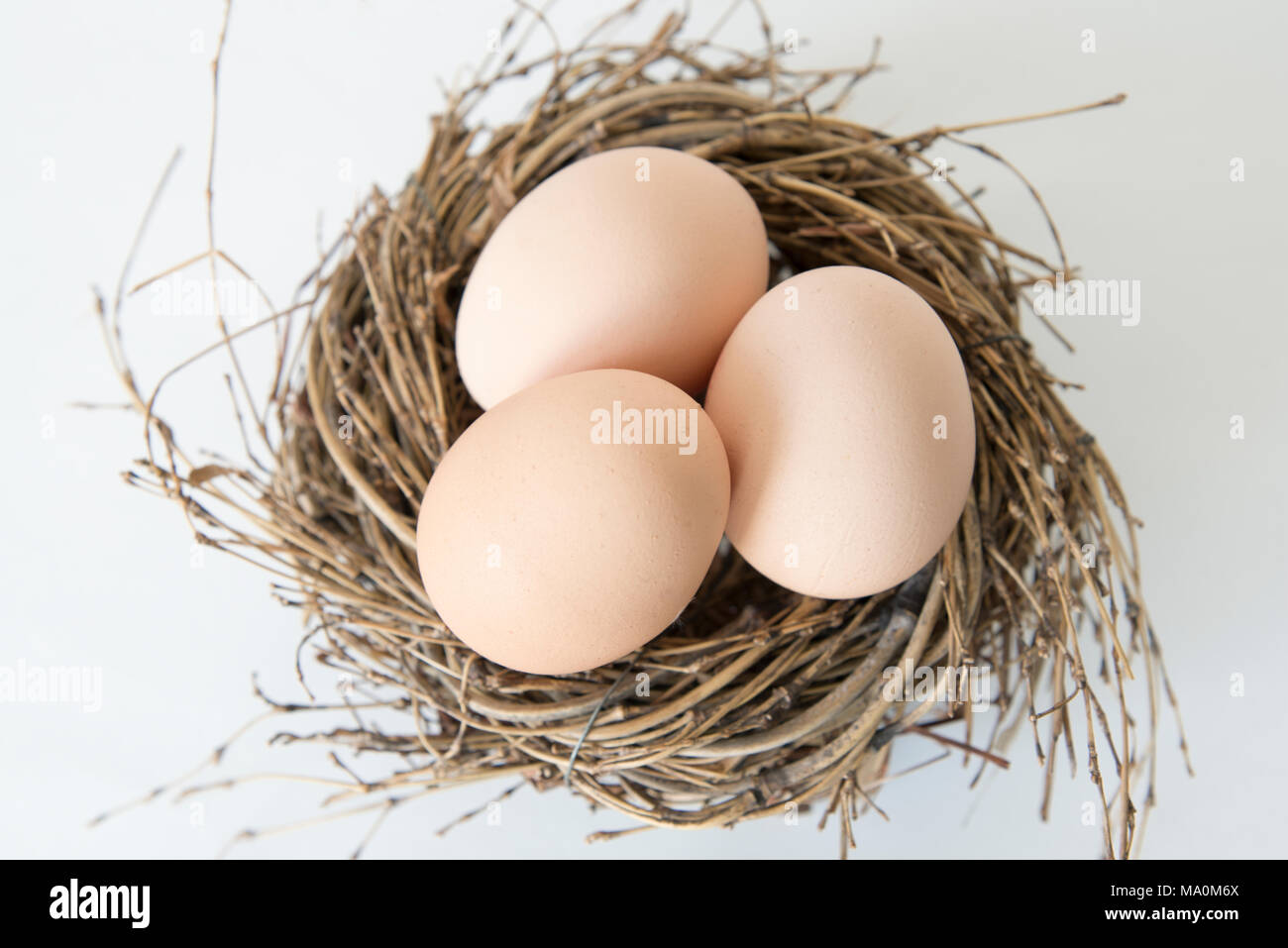 three eggs in the nest, fresh egg for breakfast, easter feast Stock Photo