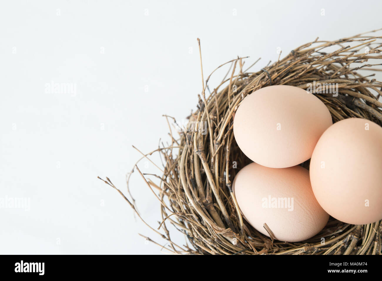 three eggs in the nest, fresh egg for breakfast, easter feast Stock Photo