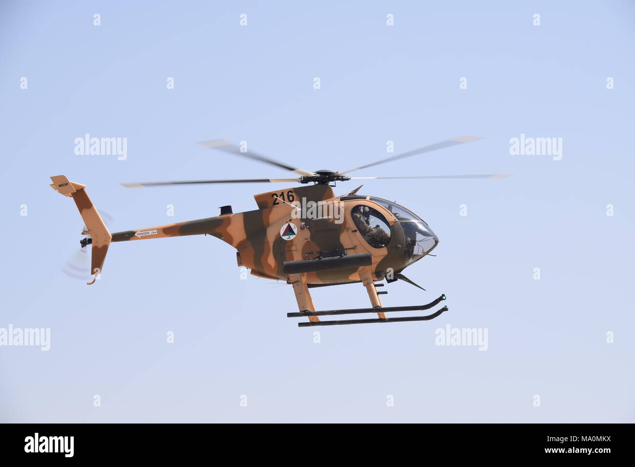 A MD 530F Cayuse Warrior light attack helicopter of the Afghan Air Force flying in the sky over the Kabul Military Training Centre (KMTC),  during an exercise. Stock Photo