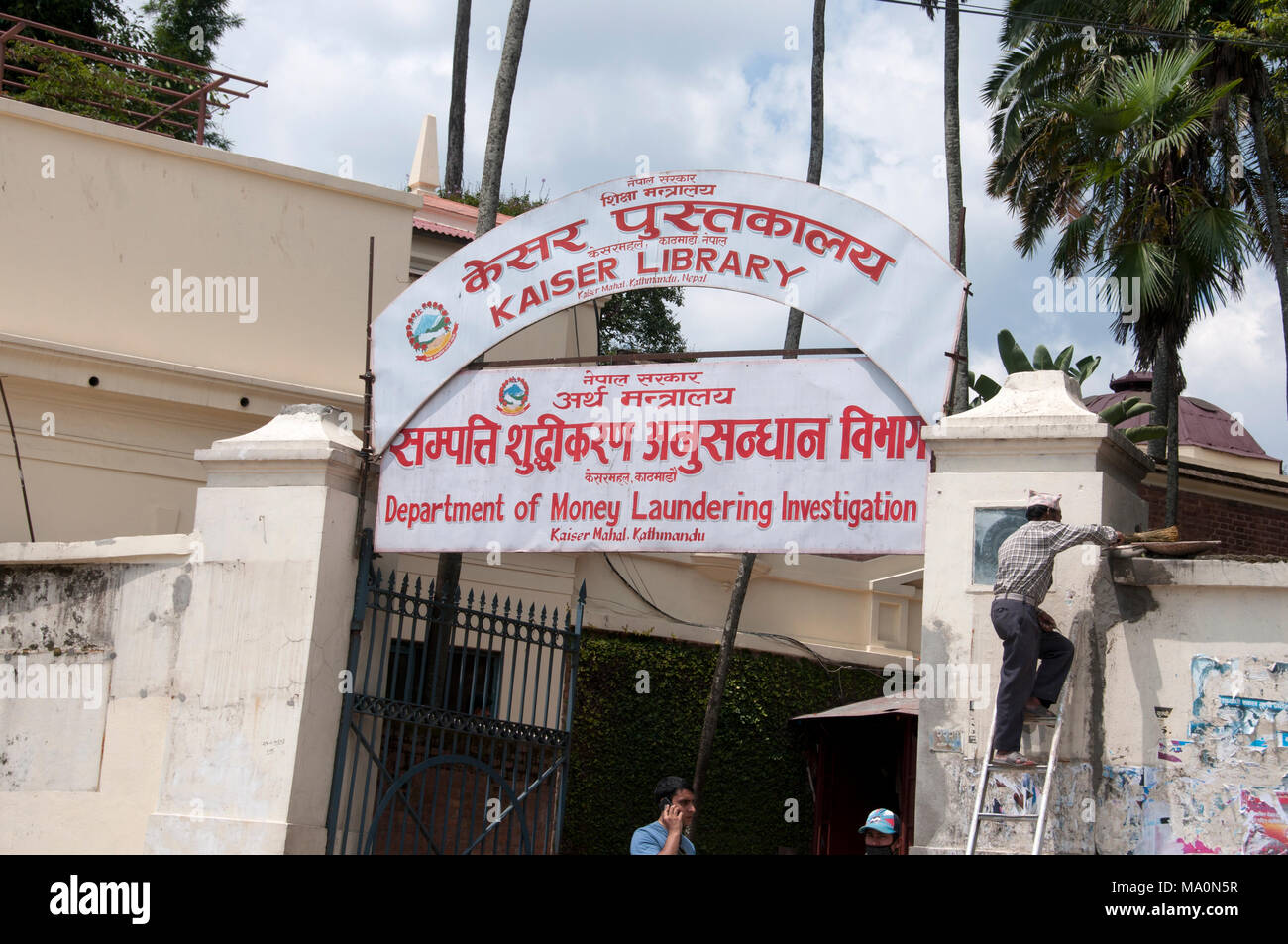 Nepal 2014. Kathmandu . Entrance to Department of Money Laundering Investigation with a man on a ladder repairing a light Stock Photo