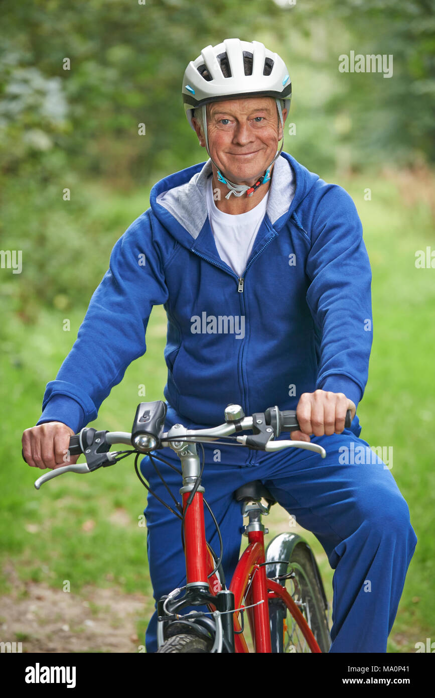Senior Man Enjoying Cycle Ride In The Countryside Stock Photo