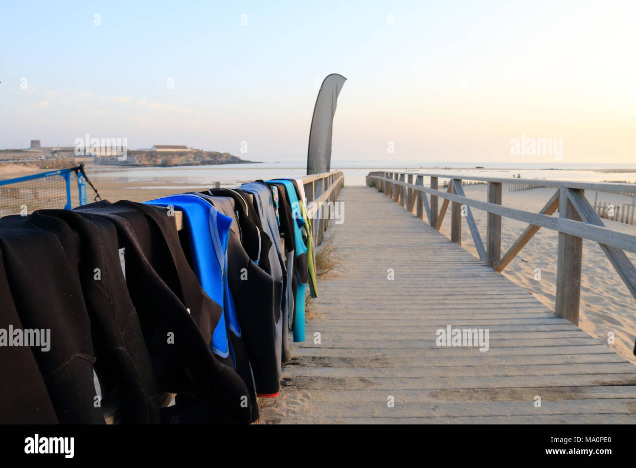 Neoprene costumes hanging on the wooden path to Tarifa beach, Spain Stock Photo