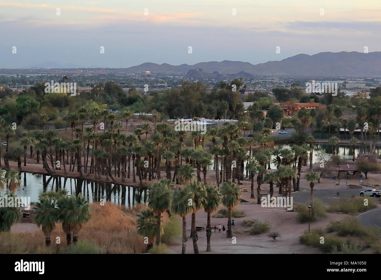 Phoenix, Arizona March 21, 2018. Red Rocks of sandstone with lagoon and palm trees at Papago