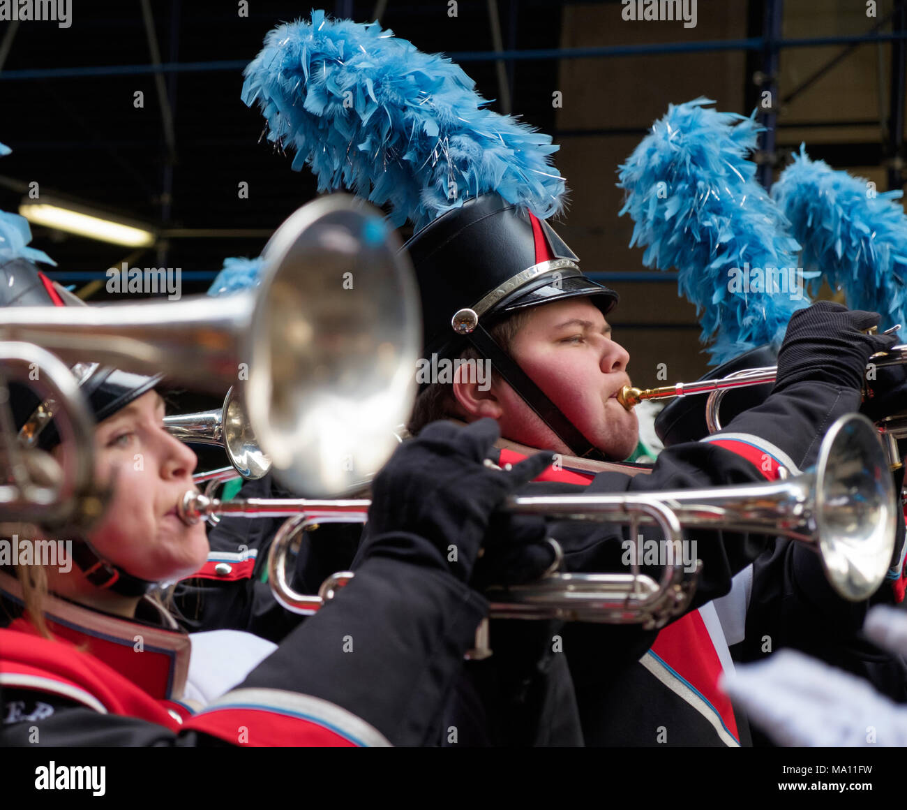 High school boy & girl blowing trumpets in St. Patrick's Day Parade in
