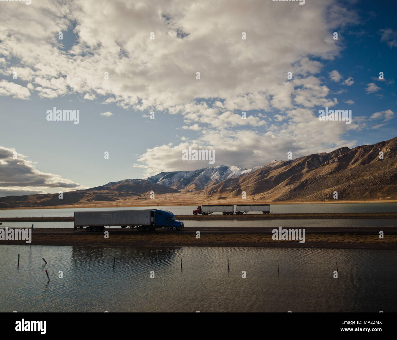 Semi Trucks driving through the Utah Salt flats on a causeway Stock