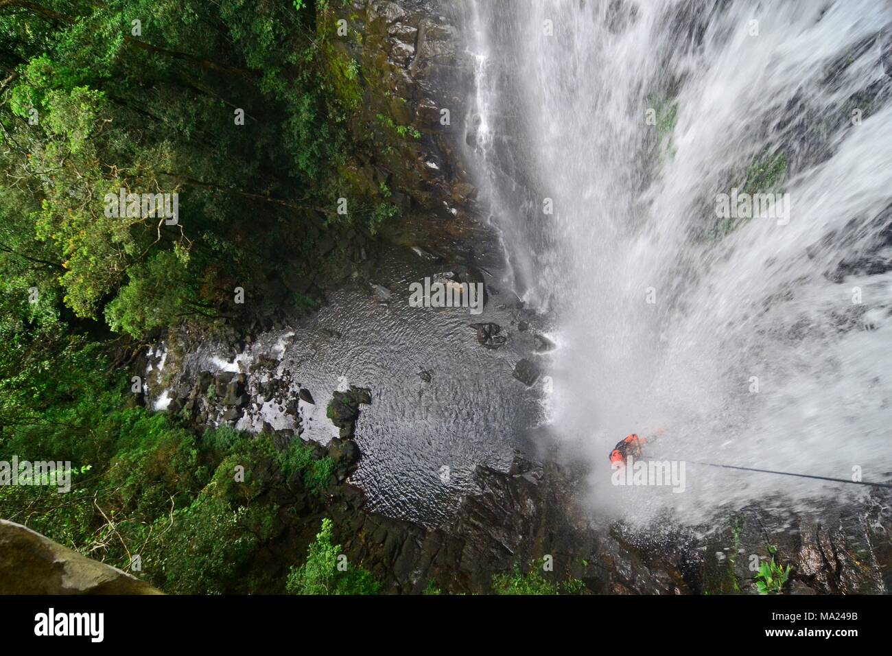 Canyoning in a waterfall 30 meters high in the stunning Aur Bunak forest in South Borneo Stock Photo