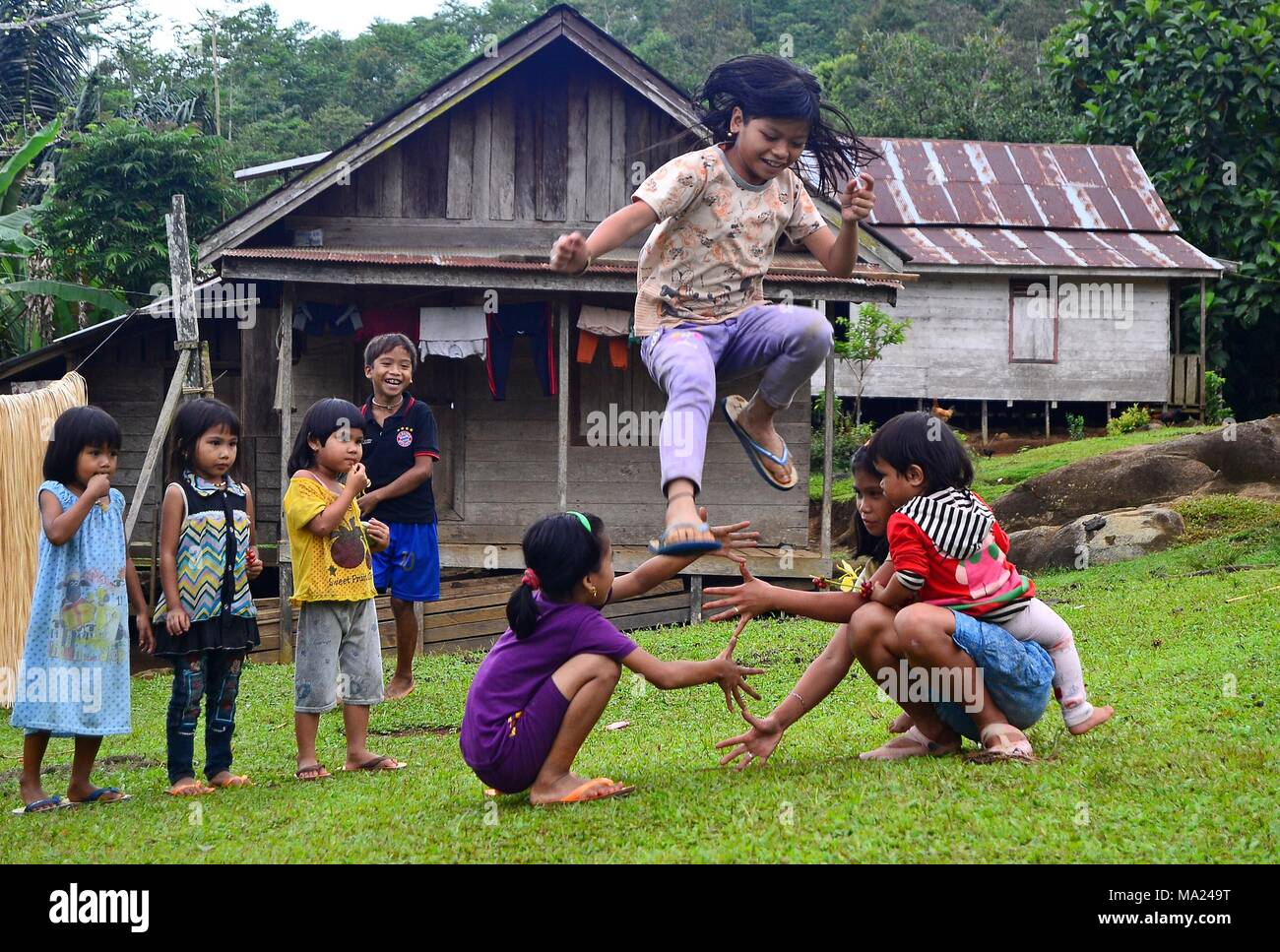 The Meratus Dayak children in South Kalimantan play with friends in the afternoon while waiting for their parents to come home from the fields. Stock Photo