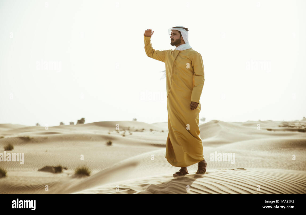 Man wearing traditional uae clothes spending time in the desert Stock Photo  - Alamy