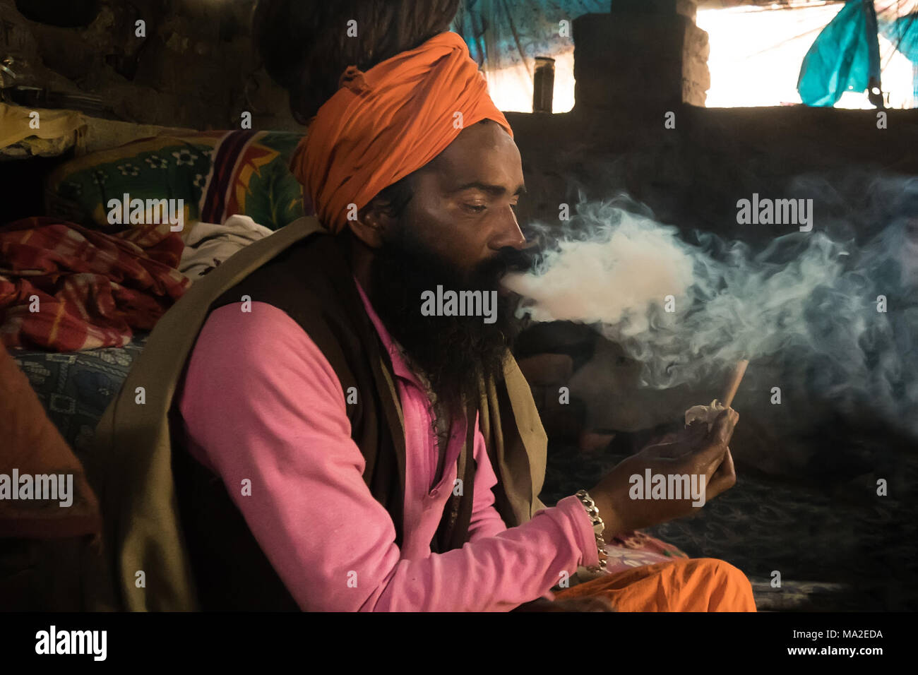 Goa, INDIA - January 11, 2018: A unidentified sadhu is smoking ganja marihuana. Babba the sacred teacher, guru and mentor smokes Smoking jamb with dru Stock Photo