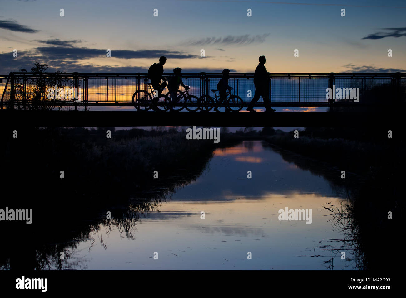 Sunset silhouettes over a canal bridge Stock Photo - Alamy