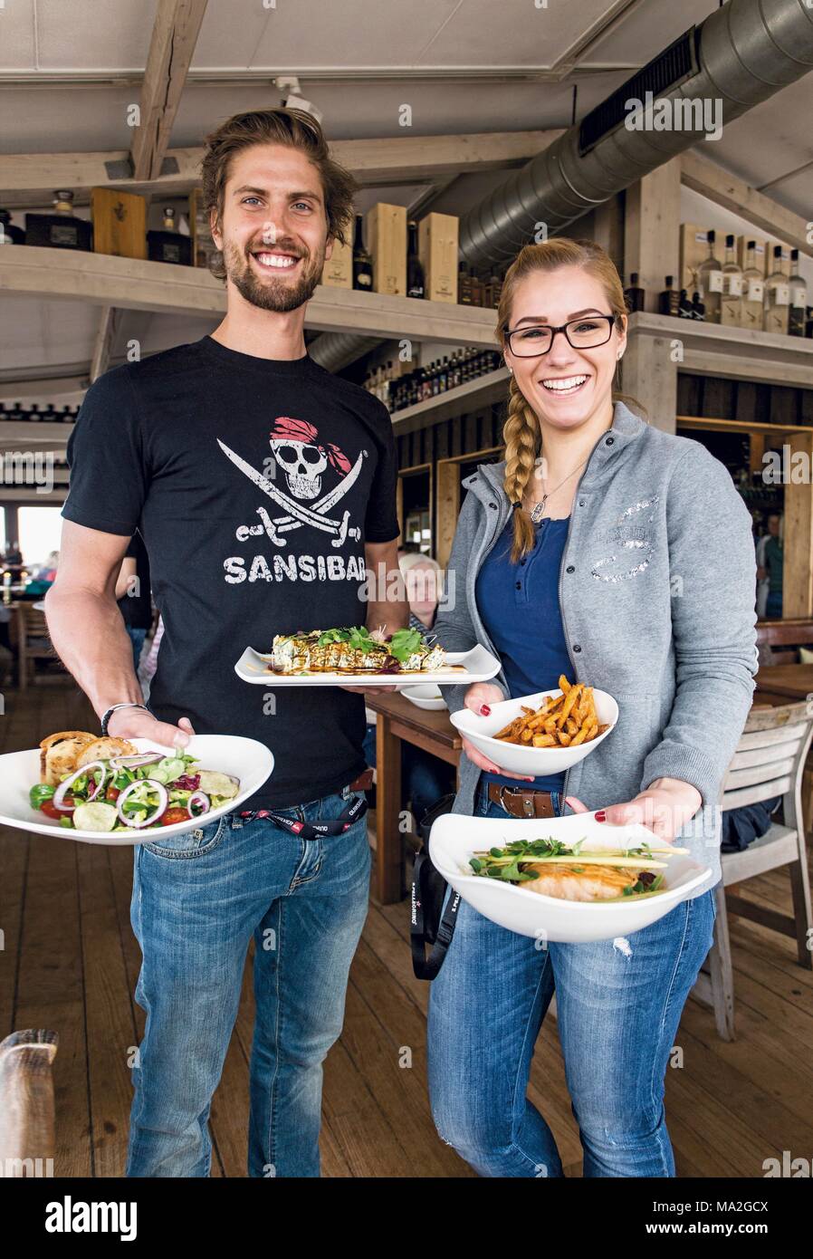 Service personnel offering fine food at the restaurant Sansibar, Sylt Stock Photo