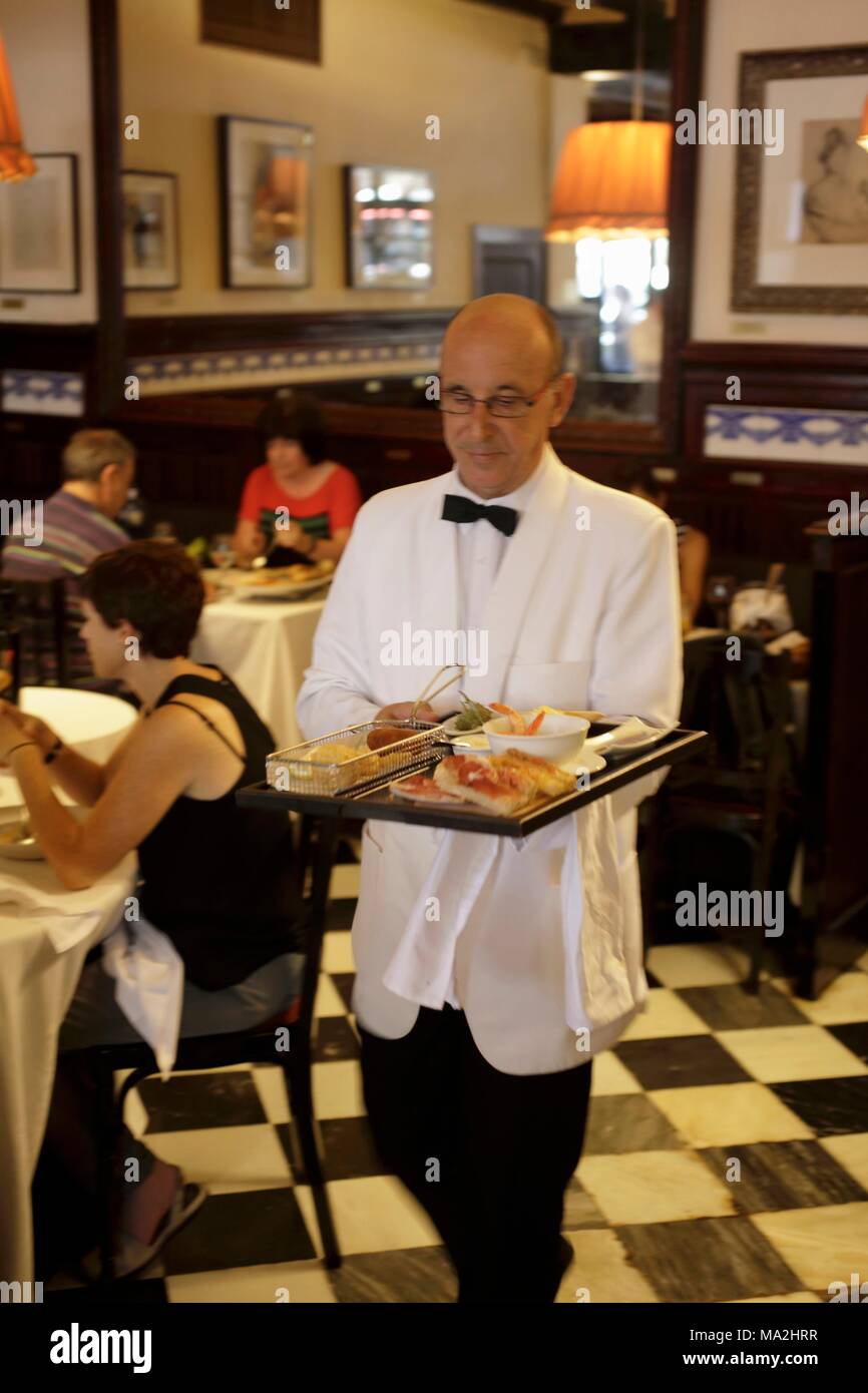 A waiter in the restaurant '7 Portes' serving tapas, Barcelona, Spain Stock Photo