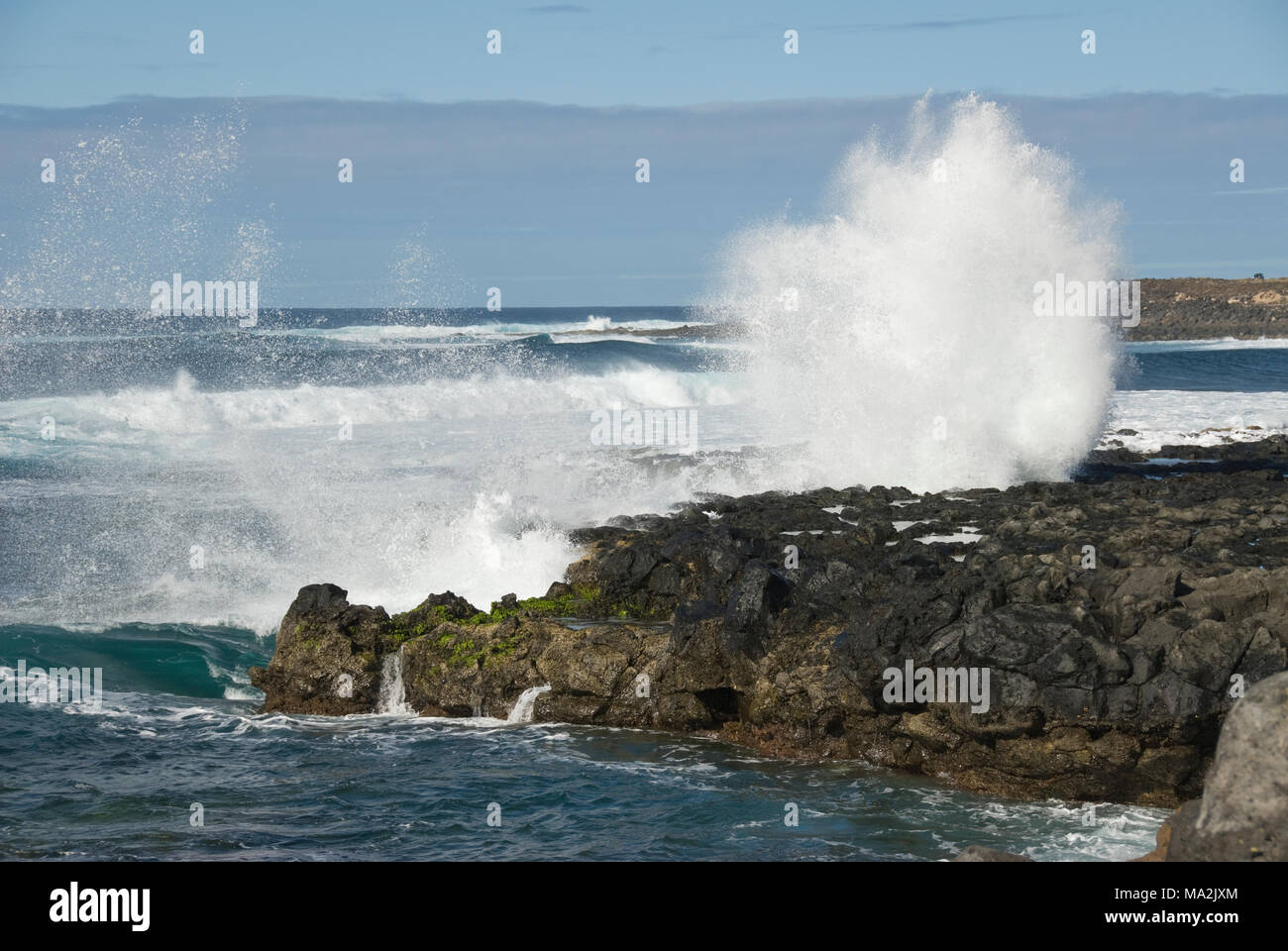Atlantic Ocean waves splashing water on rocks of Lanzarote coast Stock Photo