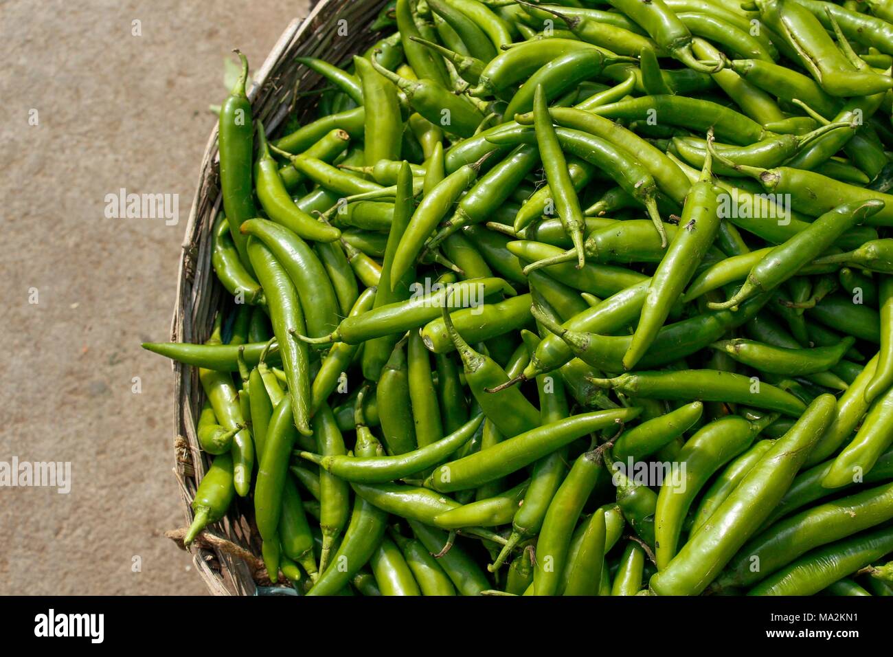 A basket of fresh green chillies on Indian market Stock Photo