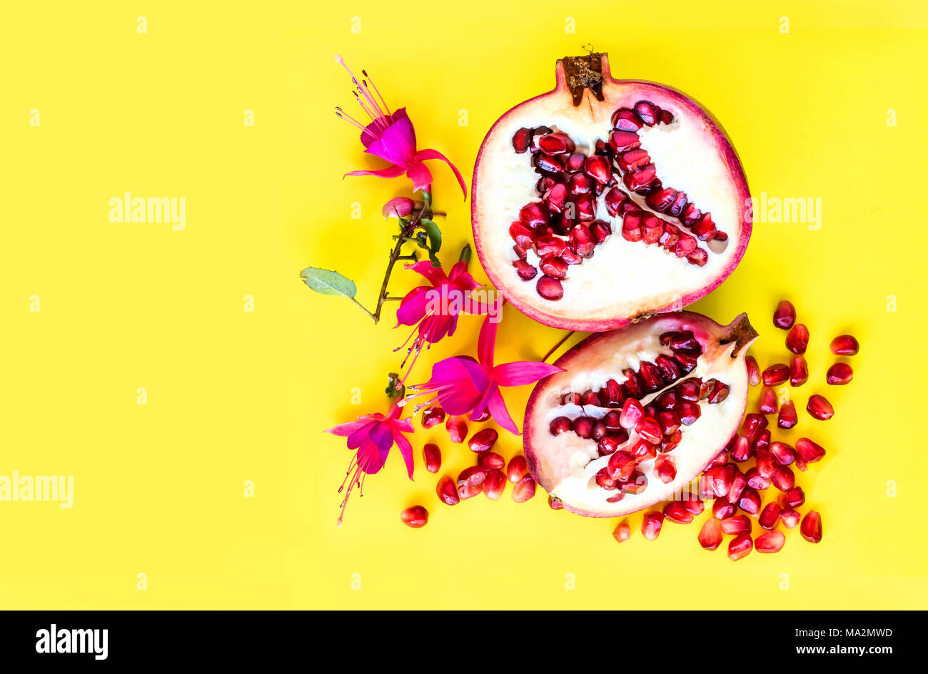 Pomegranate fruit with flowers, flat lay view. Stock Photo