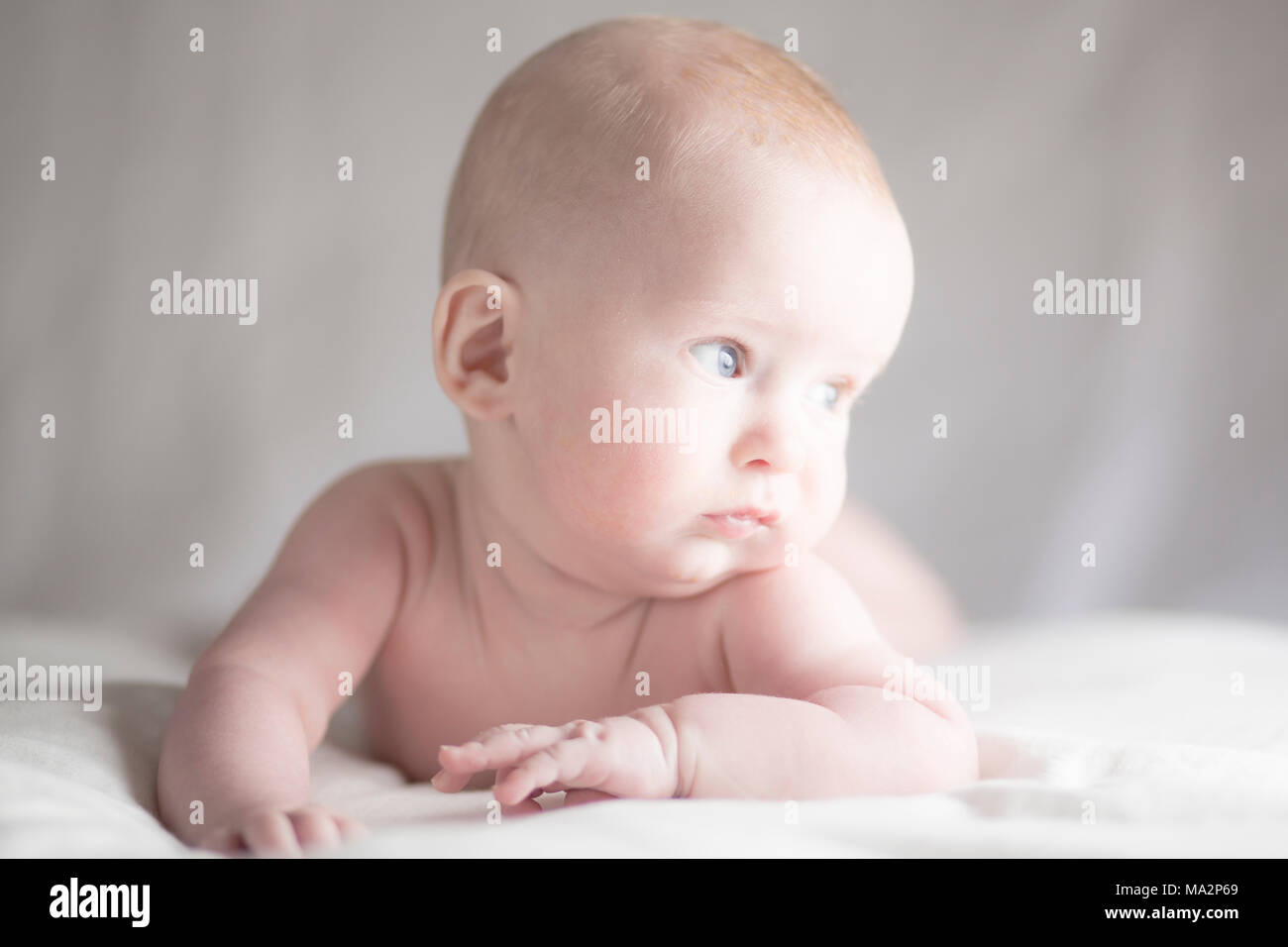 Very cute baby boy looking towards the light with contemplative ...