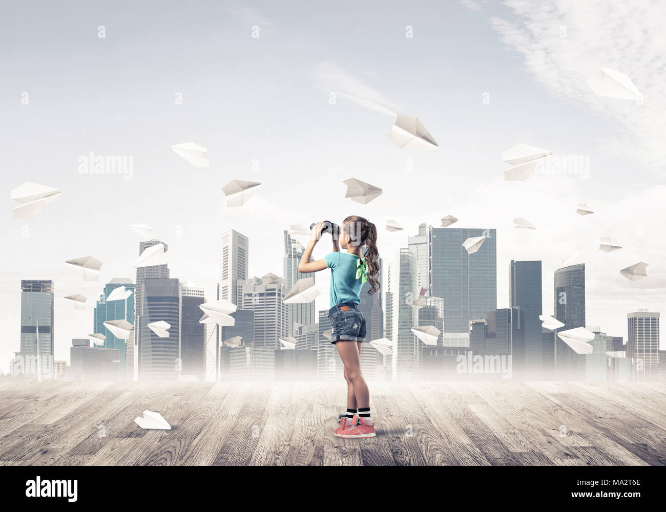 Cute kid girl stand on wooden floor and paper planes flying around ...