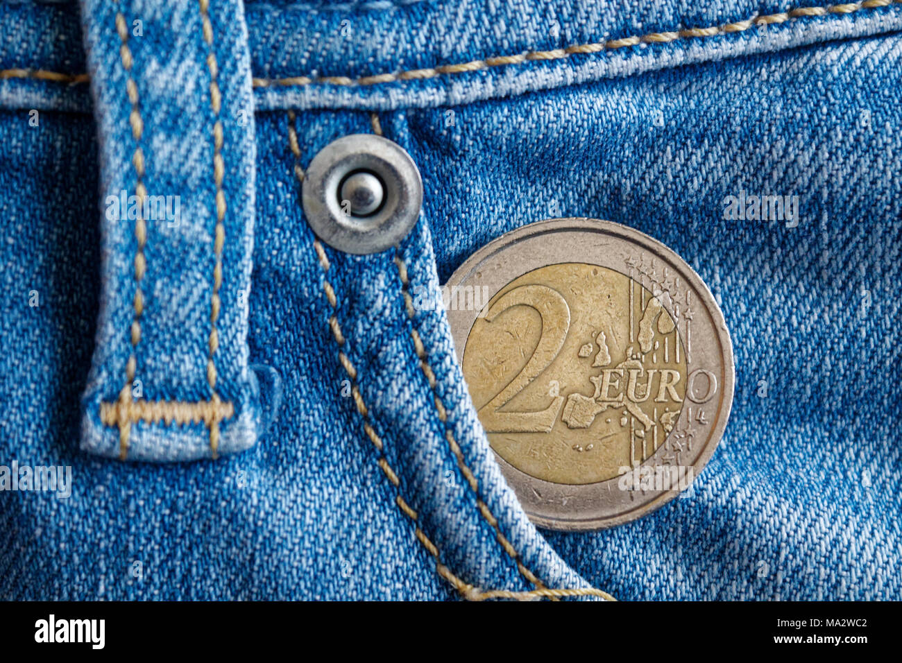 Euro coin with a denomination of 2 euro in the pocket of vintage