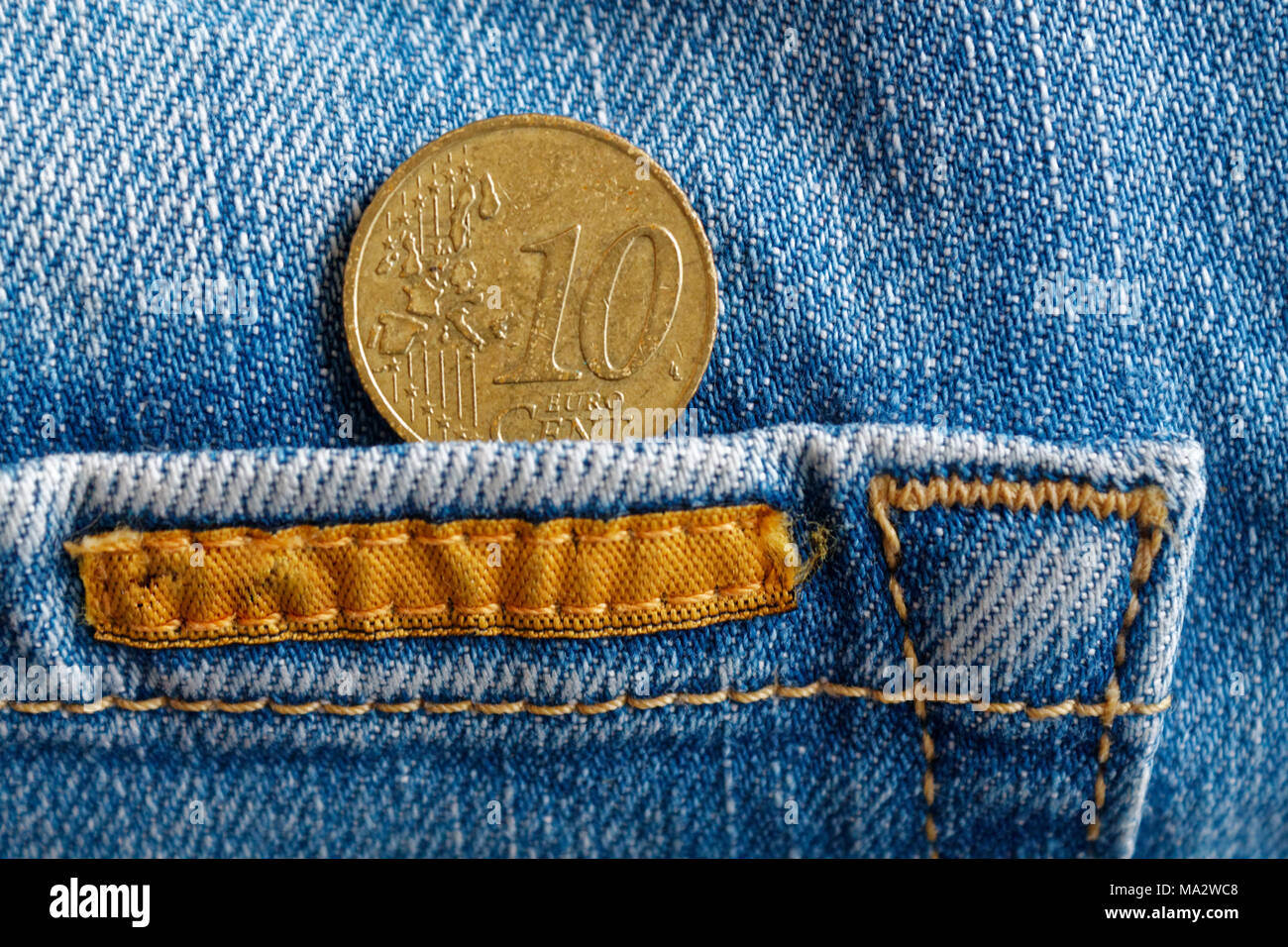 Euro coin with a denomination of 10 euro cent in the pocket of worn blue denim  jeans with orange laces Stock Photo - Alamy