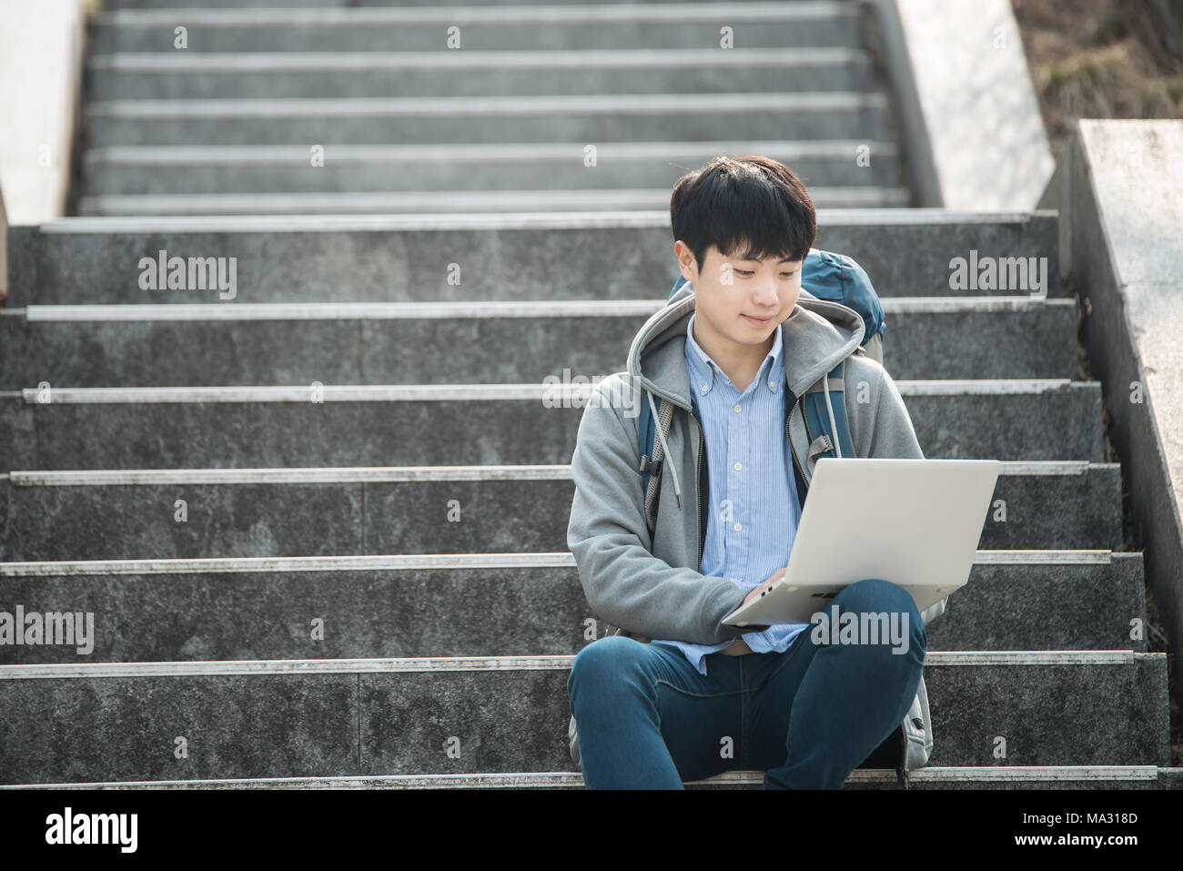 Asian man backpacking using laptop Stock Photo