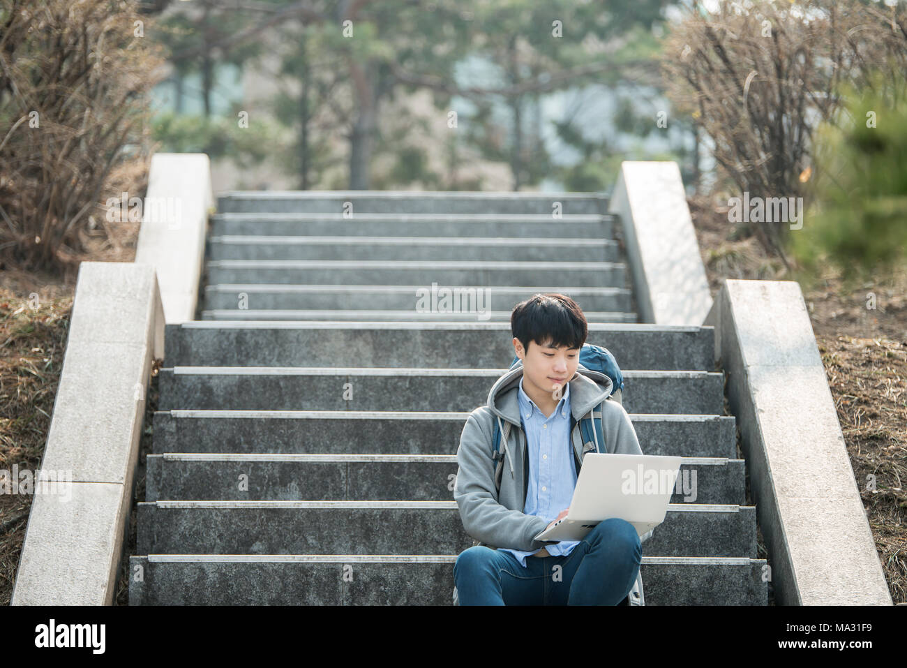 Asian man backpacking using laptop Stock Photo